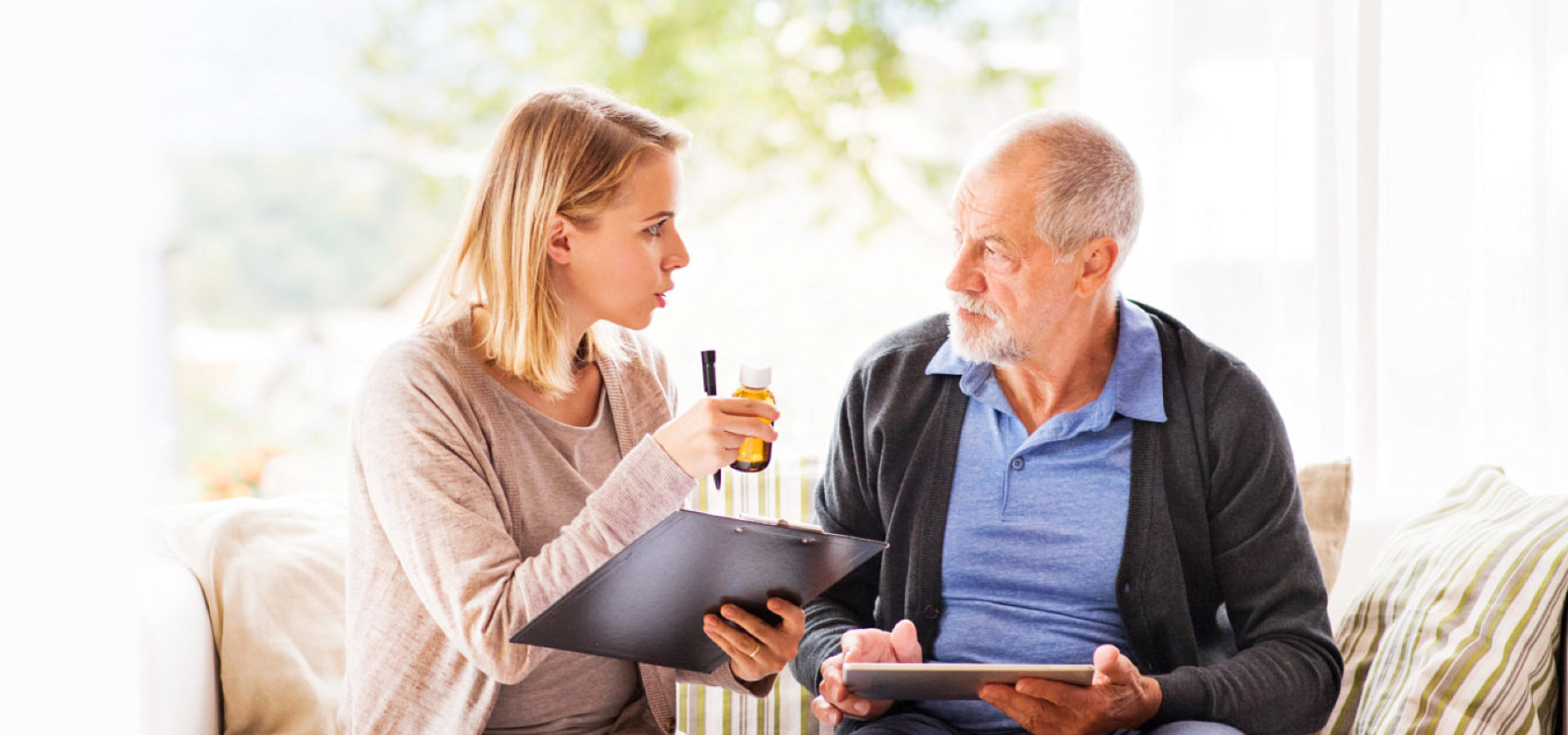 caregiver showing a medicine to a senior man