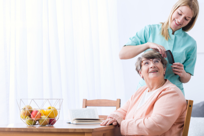 caregiver combing a senior woman